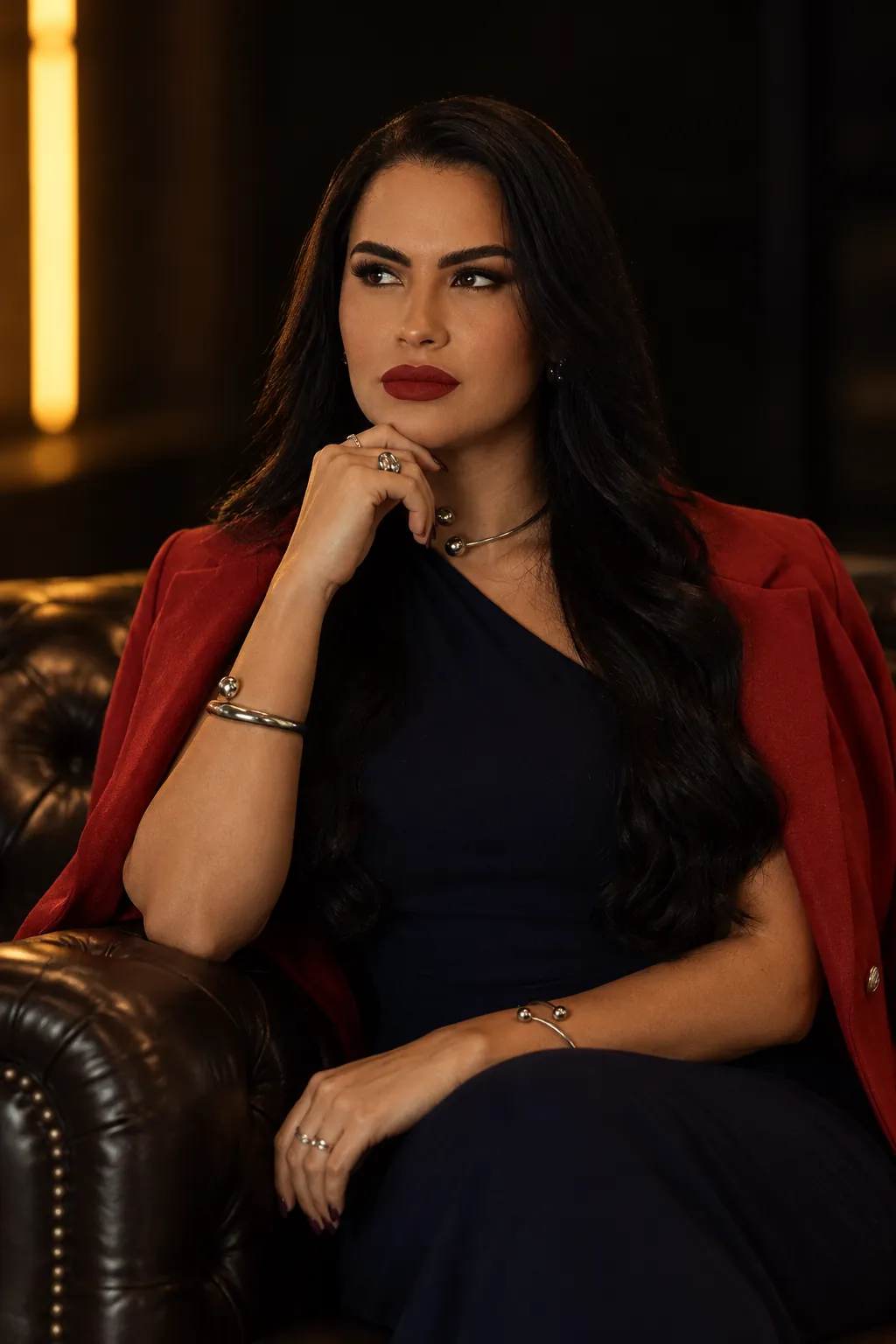 Dra. Eulayne Alves sentada em uma poltrona de couro, de blazer vermelho
